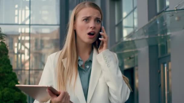 Rozčilený frustrovaný naštvaný stresu běloška podnikatelka chodit na ulici v blízkosti kanceláře mluvit hádky na mobilní telefon dívka manažer dáma podnikatel odpověď nepříjemný obchodní hovor pomocí smartphone - Záběry, video