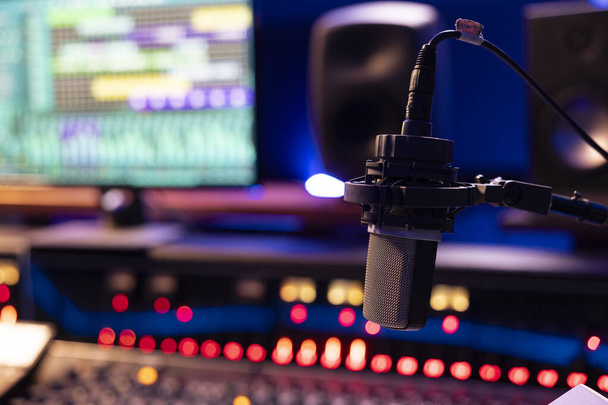 Lege controlekamer met professionele opname microfoon en technische uitrusting voor het produceren en bewerken van muziek, schuifregelaars en knoppen op paneel. Post productieruimte. Sluiten.. - Foto, afbeelding