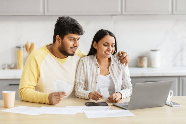 A millennial indian couple reviews their budget carefully in the kitchen, reflecting financial literacy and teamwork in their domestic partnership - Photo, Image