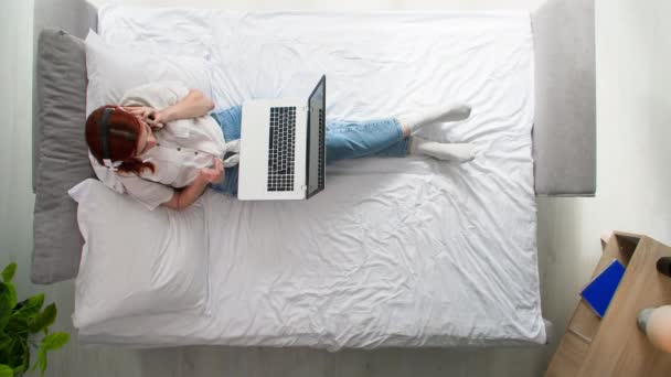 timelapse, fiatal nő pihen otthon fekszik az ágyon, felső nézet - Felvétel, videó