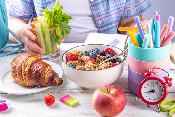 Sana colazione nutriente mattutina per i bambini delle scuole, con frutta fresca, verdure, croissant, muesli, latte e sandwich. Ragazza che fa colazione prima di scuola e lavoro, copiare lo spazio - Foto, immagini