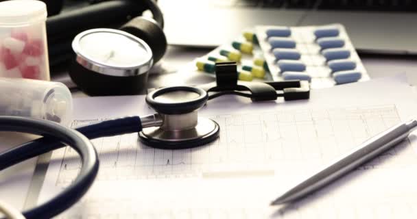 Kardiogram medyczny i leki na stole. Leczenie chorób serca - Materiał filmowy, wideo