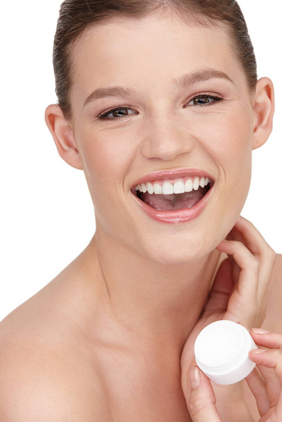 Woman, facial cream and smile in studio portrait for cosmetics, skincare or beauty exfoliation. Female person, clean and happy with anti aging mask for dermatology, wellness and acne protection. - Photo, Image
