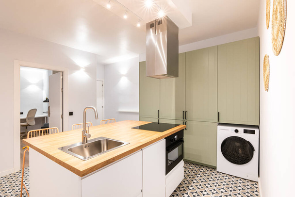 現代的なデザインのキッチンには,使用可能なアパートのスペースを使用するために必要な家具と家具が装備されています. 家族や友人との調理と快適な休暇のための豪華なキッチン - 写真・画像