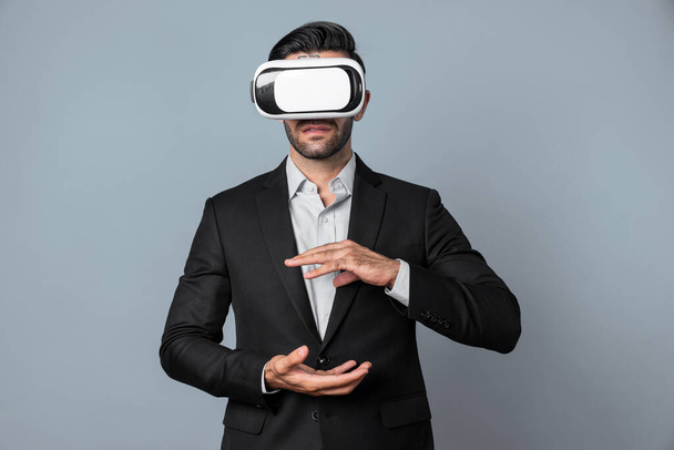 Розумний бізнесмен з костюмом, що тримає щось в той час як VR окуляри, щоб з'єднати метаверсію. Професійний менеджер проектів, який дивиться на голограму за допомогою гарнітури візуальної реальності. Технологічні інновації. Відраза. - Фото, зображення