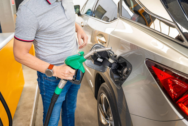 Řidič plní drahý benzin na samoobslužné čerpací stanici v Evropě. Kvalitní fotografie - Fotografie, Obrázek