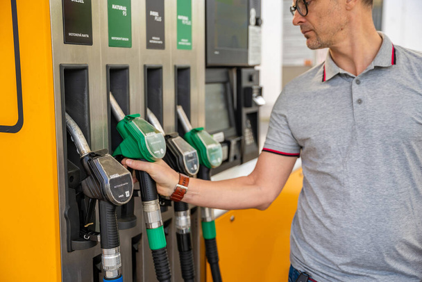 Benzin deposunda elinde benzin hortumu tutan adam Avrupa 'da daha ucuz dizele odaklanıyor. Yüksek kalite fotoğraf - Fotoğraf, Görsel