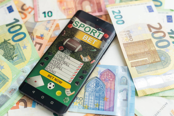 dolarů a eur, smartphone s aplikací sportovních sázek. Kvalitní fotografie - Fotografie, Obrázek