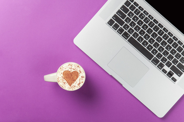 Xícara de cappuccino com forma de coração e laptop
 - Foto, Imagem