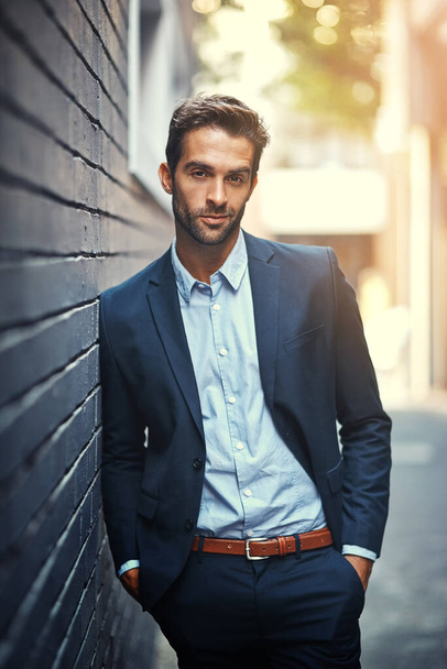 Confident, businessman and portrait in city by wall for corporate fashion, trendy and stylish suit. Male entrepreneur, professional and happy in street for travel to work or company and outdoor - Photo, Image