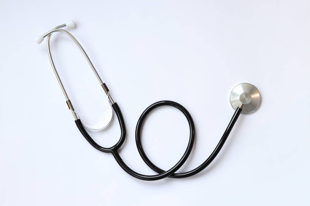 Stetoskop na bílém pozadí, pohled shora. Lékařský nástroj. Kardiologie a medicína, zdravotní péče. Auscultation device - Fotografie, Obrázek