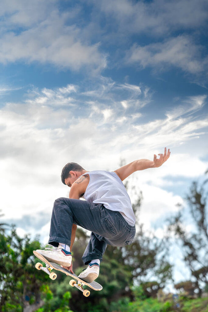 молодий чоловік стрибає з пандусом зі скейтбордом - Фото, зображення
