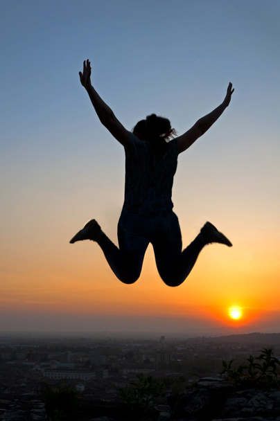 Silueta femenina saltando al atardecer
 - Foto, Imagen
