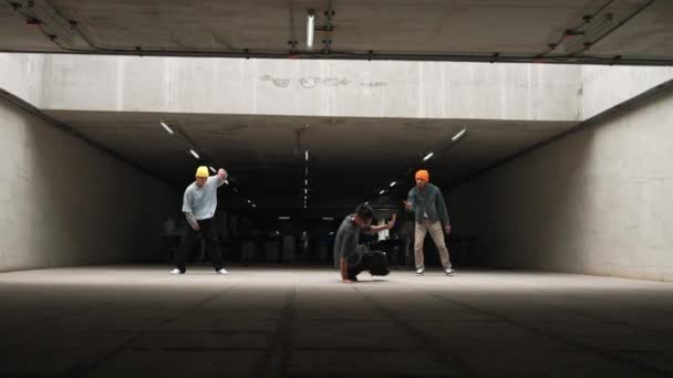 Eine Gruppe von Hipstern posiert in Freeze-Pose, während das Tanzteam zusammen tanzt. Professionelle Breakdance-Teams führen Streetdance im Gebäude mit witzigen und lebhaften Bewegungen auf. Outdoor-Sport 2024. Schwungvoll. - Filmmaterial, Video