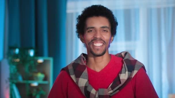 goed nieuws, portret van een vrolijke jonge zwarte man lachend en knap in de camera - Video