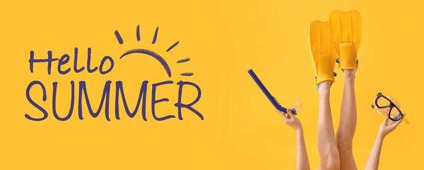 Junge Frau mit Schwimmflossen, Schnorchelmaske und Schlauch auf gelbem Hintergrund. Hallo Sommer - Foto, Bild