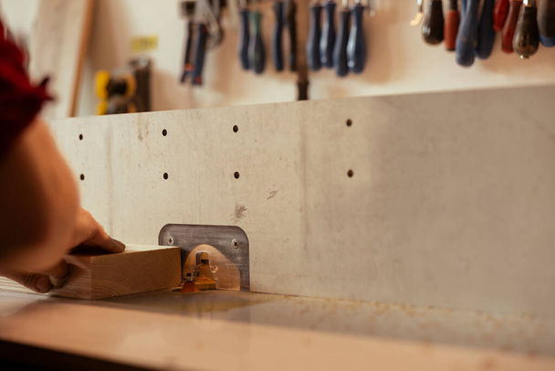 Maquinista CNC que opera moldeadora de husillos para crear una carpintería a medida de alta calidad para el proyecto encargado por el cliente. Carpintero realizando tareas en el moldeador de madera, conformación y corte de materiales - Foto, Imagen