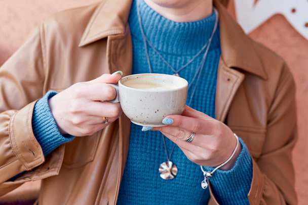 Donna con manicure blu tiene una tazza di caffè da vicino. - Foto, immagini