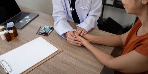 Лікар тримає руку пацієнта підбадьорювати і заохочувати під час перевірки вашого здоров'я. - Фото, зображення