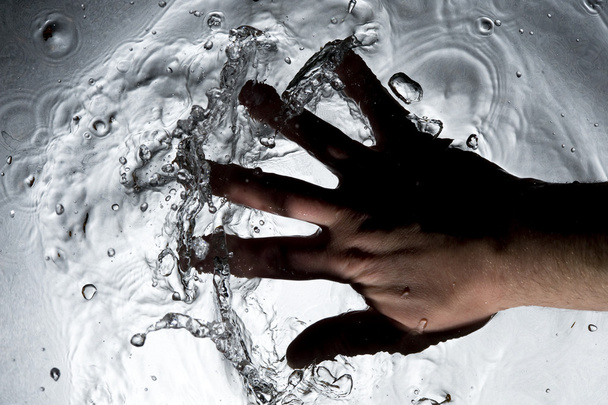 Hand on the black water - Фото, изображение