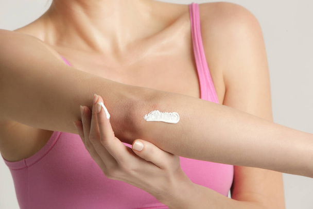 Woman applying elbow cream. Beauty and body care. Winterizing dry itchy skin on the elbow area. - Photo, Image