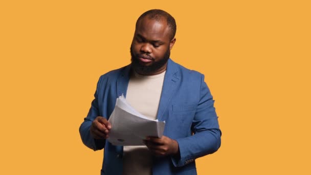 Accountant doing profit analysis for company, throwing files in air, feeling overworked, studio background. African american worker doing financial budgeting, having outburst, annoyed by too much work - Footage, Video