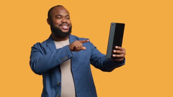 Αφροαμερικάνος κάνει αστεία συζήτηση με φίλους κατά τη διάρκεια τηλεδιάσκεψης χρησιμοποιώντας tablet, studio background. Πρόσωπο που γελάει, διασκεδάζει με συντρόφους κατά τη διάρκεια βίντεο στο διαδίκτυο, κάμερα A - Πλάνα, βίντεο