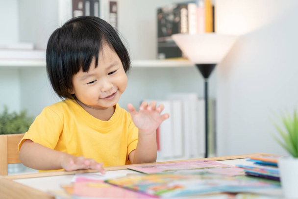 Mutlu Asyalı çocuklar evde kitap okuyarak rahatlar. Kızım ve bir hikaye okuyordum. öğrenme, çocuk bakımı, gülme, eğitim, hikaye anlatma, uygulama, hayal etme, bağımlılık cep telefonunu azaltma - Fotoğraf, Görsel