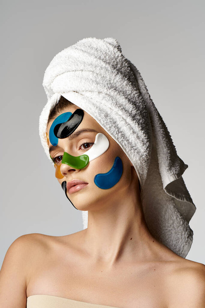 Donna graziosa con macchie sugli occhi, indossa un turbante asciugamano sulla testa, trasudando serenità e bellezza. - Foto, immagini