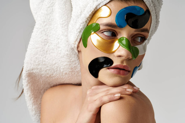 Kobieta z ręcznikiem na głowie nosi przepaski na oczy podczas objęcia samoopieki z akcesoriami do makijażu. - Zdjęcie, obraz