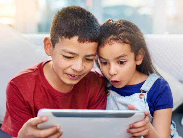 Tablet, kids and siblings on couch for play, online and esports for entertainment. Technology, streaming and internet for video wow expression in lounge, gaming and digital on touchscreen in home. - Photo, Image
