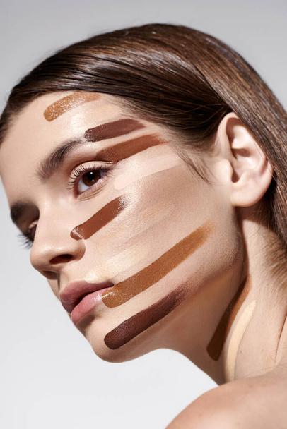 Dobře vypadající mladá žena zdobené vrstvami základů, ukazuje složité make-up umění. - Fotografie, Obrázek