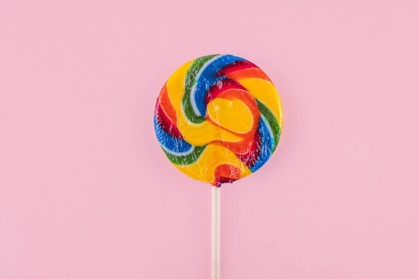 Разноцветная радуга крутила конфеты на палочке. Цветной леденец на ярком фоне, флаг ЛГБТ, детский день, концепция летнего отдыха - Фото, изображение