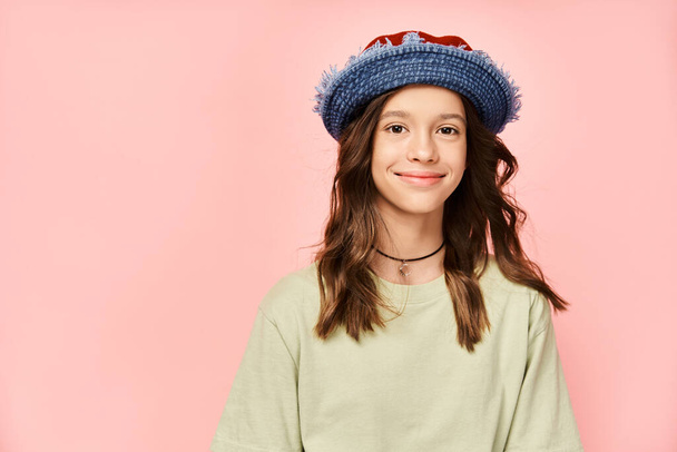 Ein stilvolles Teenager-Mädchen posiert energisch mit blauem Hut und grünem Hemd. - Foto, Bild