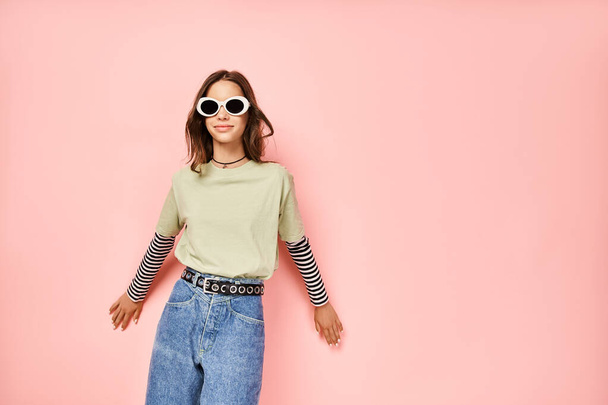 Egy stílusos tinédzser lány magabiztosan pózol élénk zöld ingben és divatos napszemüvegben.. - Fotó, kép