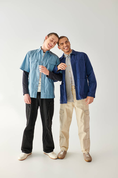 Dwóch mężczyzn, kochająca się para gejów, stoi obok siebie na białym tle. - Zdjęcie, obraz