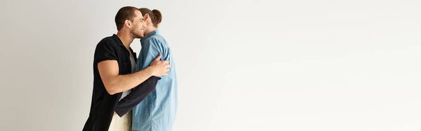 Muž pevně objímá svého partnera pod modrou přikrývkou. - Fotografie, Obrázek