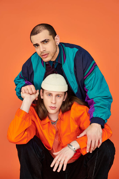 Un hombre con una camisa naranja y un hombre con una chaqueta azul, una pareja gay amorosa. - Foto, imagen