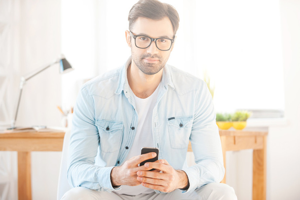 Homme en chemise et lunettes tenant un téléphone portable
 - Photo, image