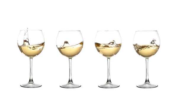 Λευκό κρασί που στροβιλίζονται σε ένα ποτήρι κρασί Κύπελλο, απομονωμένη σε ένα λευκό  - Φωτογραφία, εικόνα