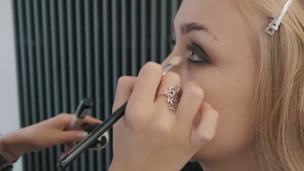 Makeup καλλιτέχνης εφαρμογή σκιά ματιών σε μια γυναίκα - Πλάνα, βίντεο