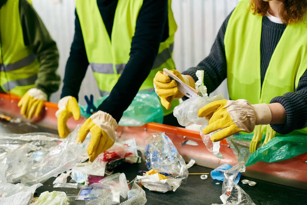 Young volunteers in yellow vests and gloves come together to sort through trash, showcasing their eco-conscious efforts. - Foto, Imagem