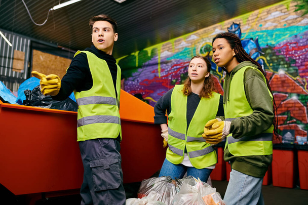 A group of young volunteers in gloves and safety vests standing together, sorting trash for a cleaner environment. - Photo, image