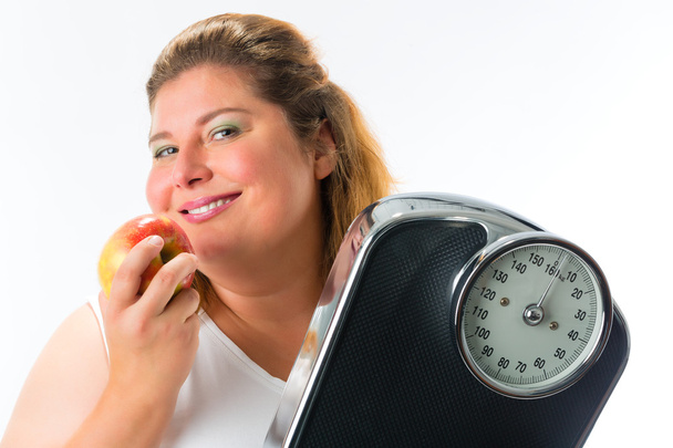 Elhízott asszony skála és almával - Fotó, kép