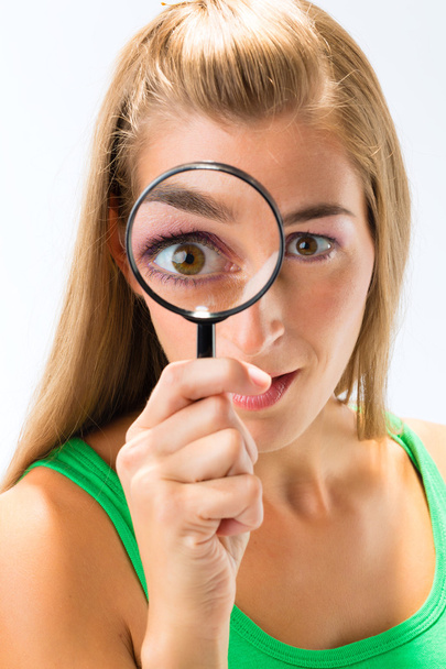 Woman looking through magnifying glass - Photo, Image