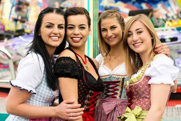 4 hermosas mujeres jóvenes en la feria alemana
 - Foto, imagen