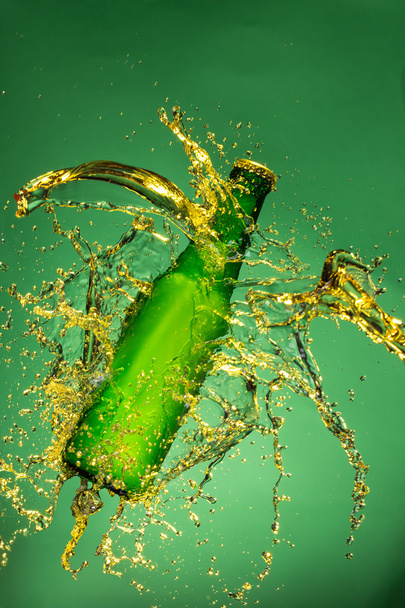 Green beer bottle with splashing liquid - Foto, Imagem