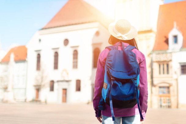 Тисячолітню жінку схопили за прогулянки на відкритому повітрі з рюкзаком, викликаючи дух молодого студента, який досліджує європейські вулиці, вид ззаду - Фото, зображення