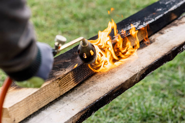 Burning Charring Wood Board with Fire Flame je způsob, jak chránit dřevo. Moderní konzervační dřevo pro použití venku. - Fotografie, Obrázek
