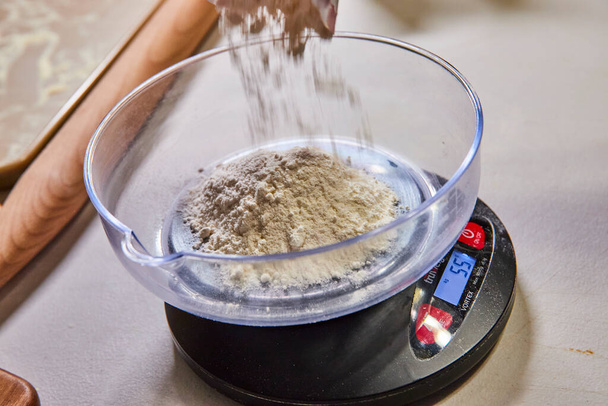 Precisione nella cottura con un primo piano di farina pesata per la pasta fatta in casa su una bilancia da cucina in Indiana - Foto, immagini